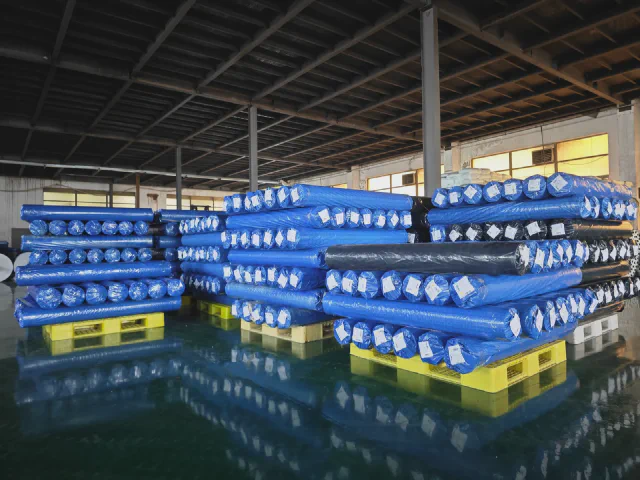 Packed blue woven rolls staged in warehouse for export shipment